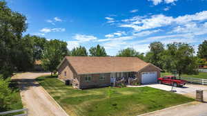 Ranch-style house featuring concrete driveway, a garage, and brick siding