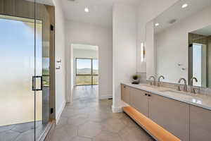 Bathroom with double vanity, recessed lighting, a shower stall, baseboards, and tile patterned floors