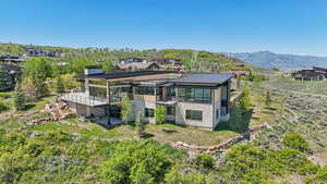View of front of property with stairs, a standing seam roof, a deck with mountain view, and stone siding
