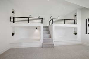 Staircase with carpet flooring, built in shelves, and baseboards