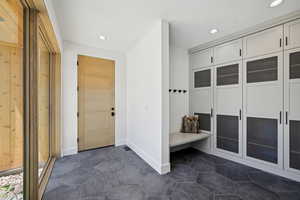 Mudroom featuring recessed lighting, baseboards, and dark tile patterned floors