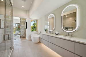 Bathroom featuring double vanity, a freestanding bath, a stall shower, tile patterned floors, and recessed lighting