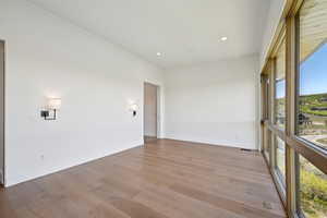 Spare room featuring light wood-type flooring, baseboards, and recessed lighting