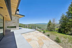 View of patio / terrace featuring an outdoor stone fireplace and a mountain view
