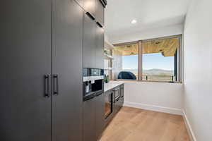 Kitchen with modern cabinets, baseboards, light wood-style floors, recessed lighting, and open shelves