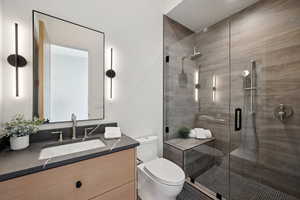Full bath featuring toilet, vanity, and a stall shower