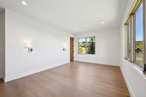 Empty room featuring baseboards, light wood-style floors, and recessed lighting