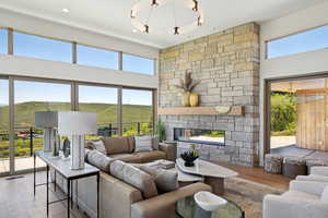 Living room with a stone fireplace and a high ceiling