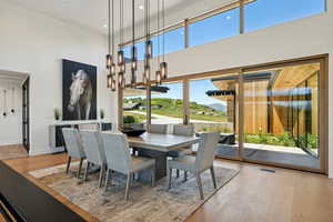 Dining space featuring a towering ceiling, wood finished floors, recessed lighting, and baseboards