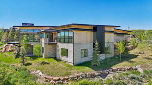View of home's exterior with stone siding and a sunroom