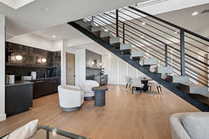 Living area featuring light wood finished floors, stairway, and recessed lighting