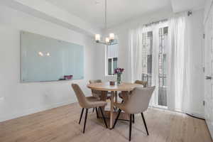 Dining room featuring plenty of natural light, a chandelier, and wood finished floors