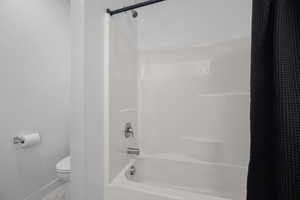 Bathroom featuring baseboards and shower / tub combo