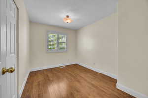 Unfurnished room with wood finished floors and baseboards