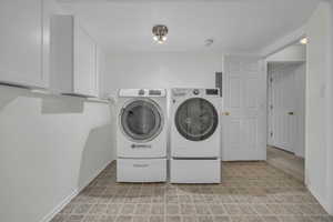 Laundry area featuring cabinet space and separate washer and dryer