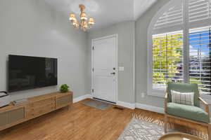 Entrance foyer featuring a chandelier, wood finished floors, and healthy amount of natural light