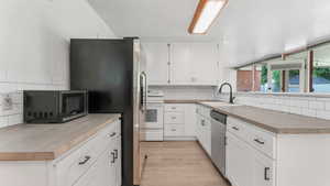 Kitchen with a sink, stainless steel appliances, and decorative backsplash
