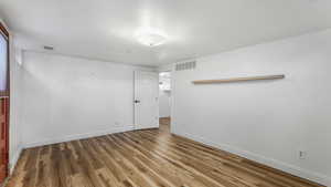 Mother-in-law living space featuring baseboards and wood finished floors