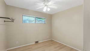 Empty room featuring light wood-type flooring, baseboards, and a ceiling fan