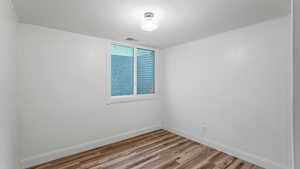Unfurnished room with light wood-style flooring and baseboards