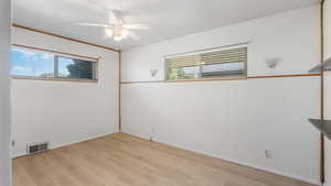 Empty room with light wood-style flooring and a ceiling fan