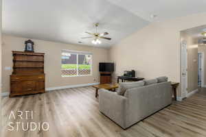 Living area with a ceiling fan, light wood-style floors, lofted ceiling, and baseboards