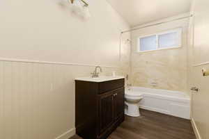 Bathroom featuring toilet, wood finished floors, shower / bath combination, and vanity