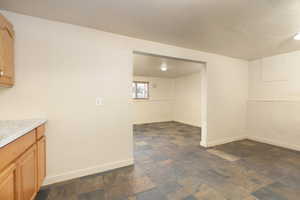 Basement featuring dark stone finish floors and a textured ceiling