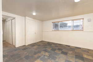 Below grade area featuring a textured ceiling and dark stone finish flooring