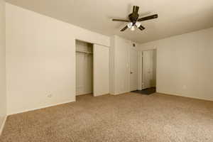 Unfurnished bedroom with carpet floors, a closet, baseboards, and ceiling fan