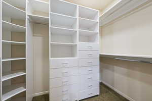 Walk in closet featuring dark carpet