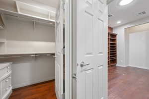 Spacious closet with dark wood-style floors