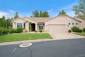 View of front of home with an attached garage, concrete driveway, a front yard, a tile roof, and stucco siding