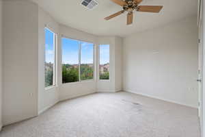 Unfurnished room featuring healthy amount of natural light, carpet floors, and ceiling fan
