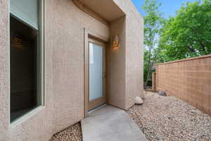 View of exterior entry with stucco siding