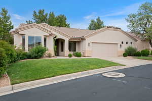 View of front facade with a garage, a front lawn, a tiled roof, stucco siding, and concrete driveway