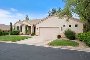 Mediterranean / spanish-style house with an attached garage, a tile roof, stucco siding, and concrete driveway