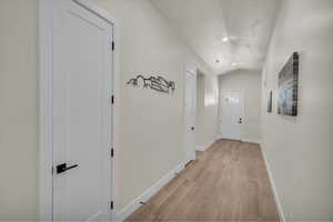 Hall with light wood-style flooring, vaulted ceiling, and recessed lighting