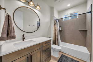 Bathroom featuring vanity, shower / tub combo, and wood finished floors