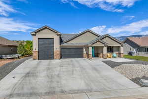 View of front of house with stone siding, an attached garage, a porch, and concrete driveway