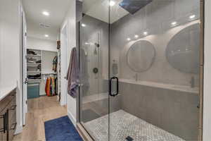 Full bathroom featuring vanity, a stall shower, wood finished floors, a spacious closet, and recessed lighting