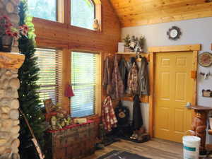Entrance foyer with wood finished floors, lofted ceiling, healthy amount of natural light, and a fireplace