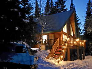 Snow covered property featuring stairs and faux log siding