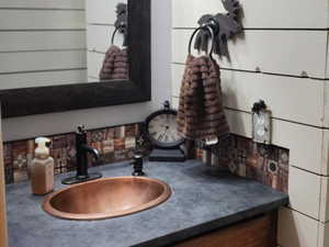 Bathroom featuring vanity and wood walls
