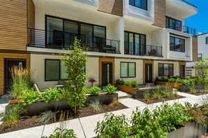 View of front of home with stucco siding and a balcony