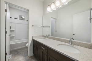 Full bathroom with quartz countertops and tile floors