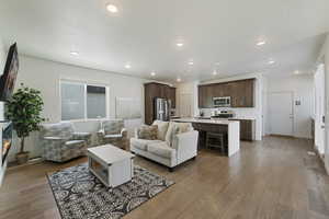 Living room with wood finished floors, recessed lighting, and baseboards