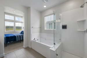 Luxurious primary bathroom with private soaker tub and semi euro glass enclosure shower.