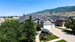 View of front facade with concrete driveway, board and batten siding, and a mountain view