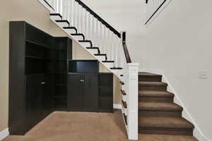 Stairway with carpet floors and baseboards